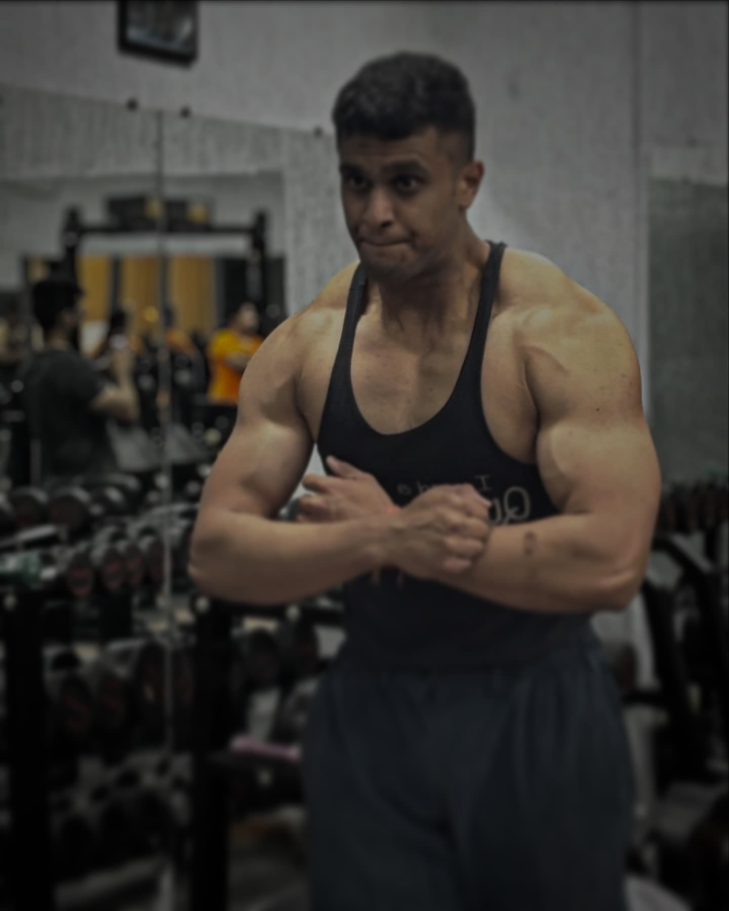 Shirtless male bodybuilder holding dumbbells